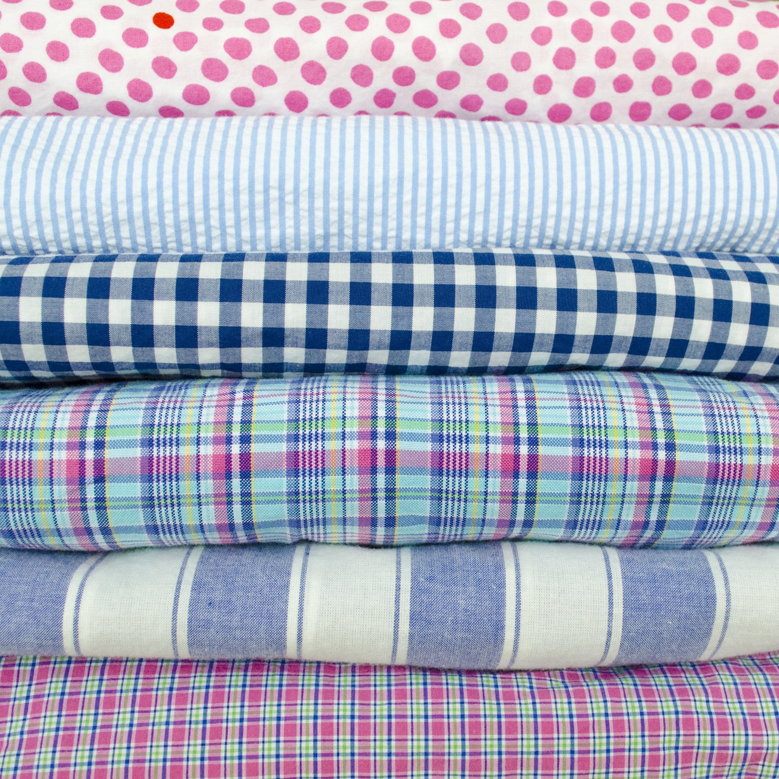 Stack of preppy shirts with plaid, gingham and polka dots