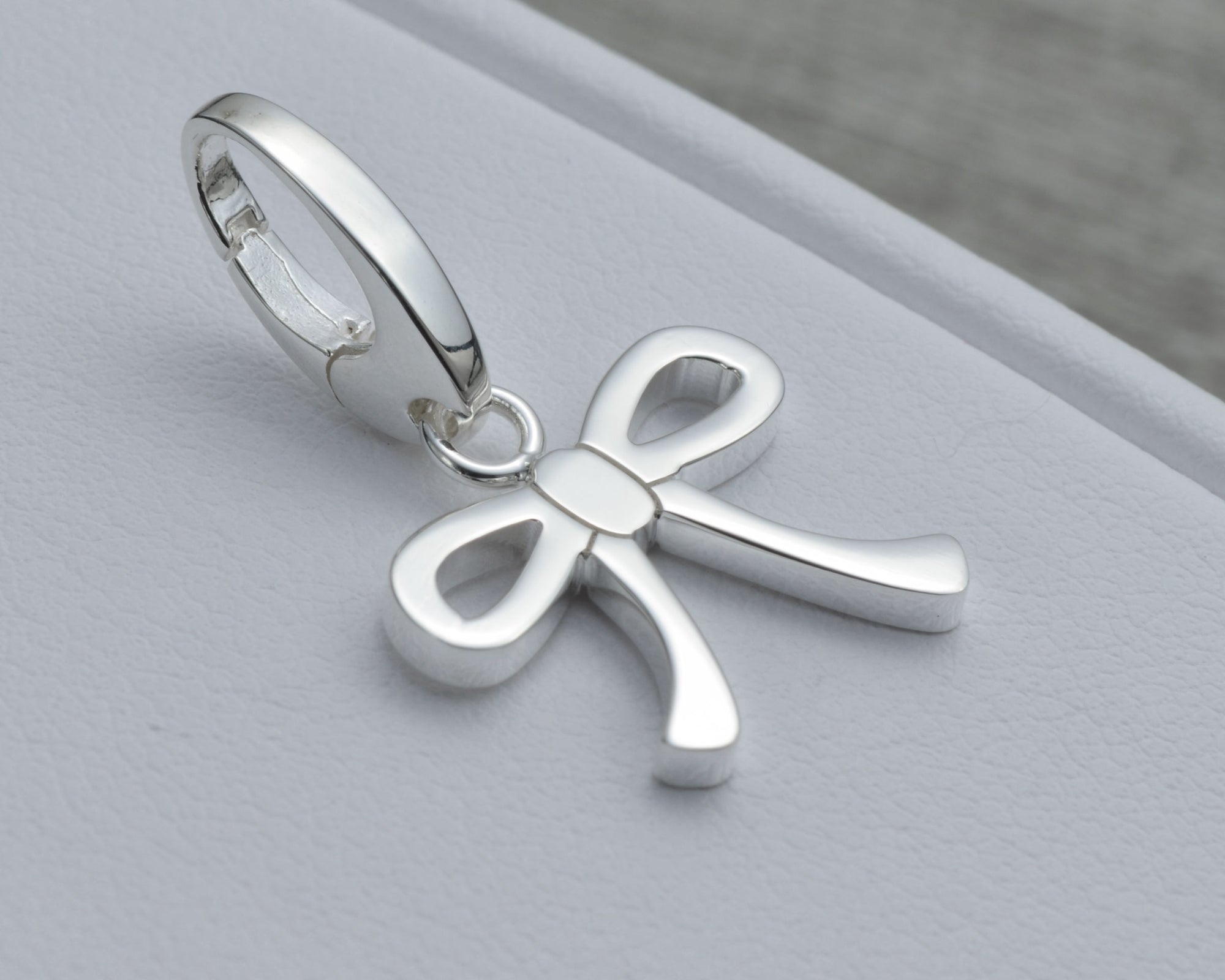 BOW CHARM IN STERLING SILVER