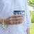 Woman holding blue and white ceramic coffee mug wearing a sterling silver charm bracelet with sterling silver charms